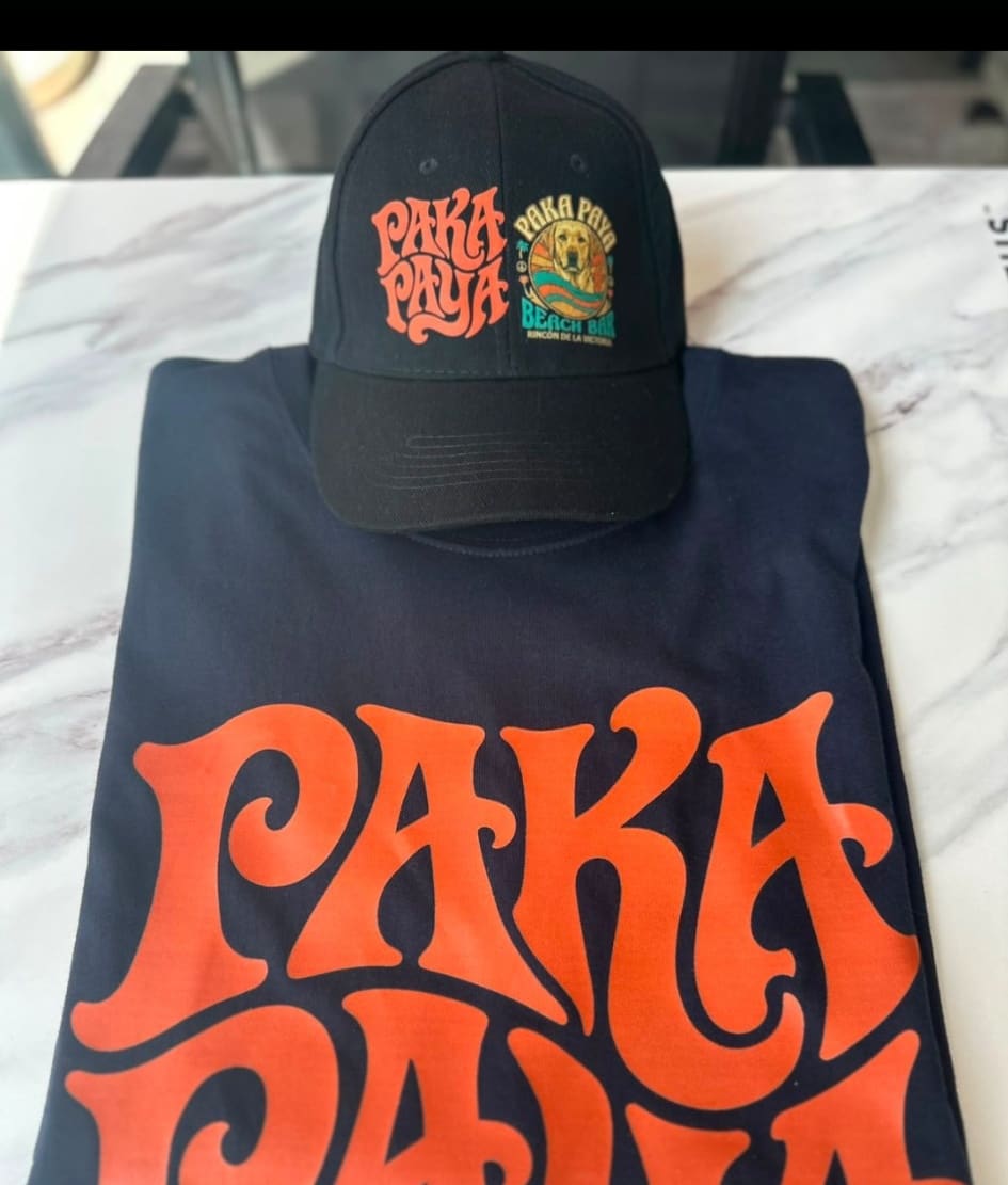 Camiseta azul marino con el logo PakáPayá delante y gorra negra a juego