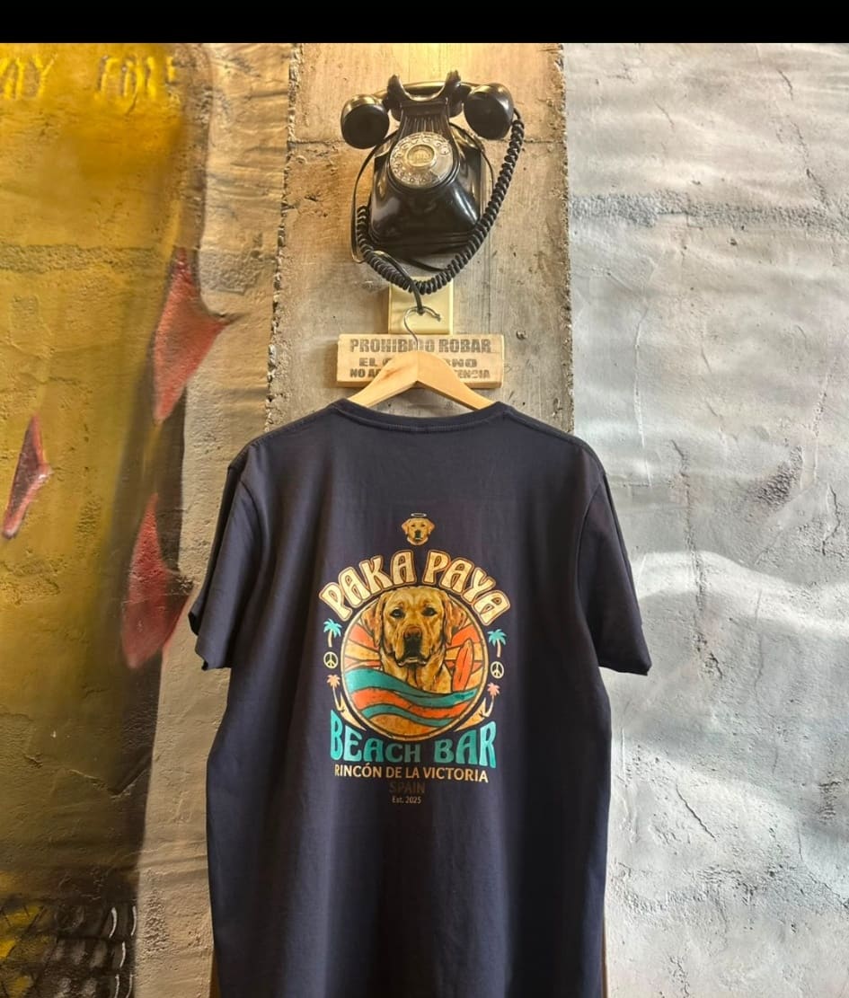 Camiseta azul marino PakáPayá colgada, estampado Beach Bar en la espalda