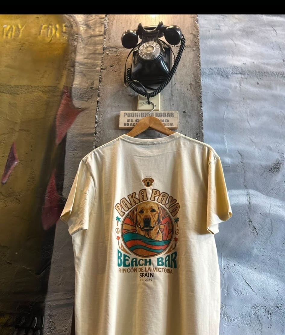 Camiseta crema PakáPayá colgada, estampado Beach Bar en la espalda