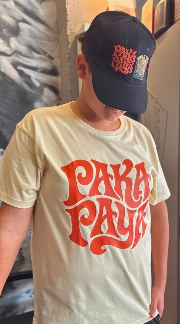 Chico con gorra negra y camiseta crema PakáPayá con el logo delante